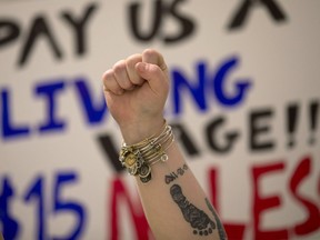 A fast-food worker raises her fist during a rally for a $15 an hour wage in Albany, N.Y., in 2015.