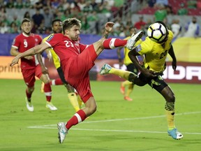Canada's Michael Petrasso moves to strike the ball as Jamaica's Kemar Lawrence heads it out of the way during a CONCACAF Gold Cup quarterfinal on July 20, 2017, in Glendale, Ariz.