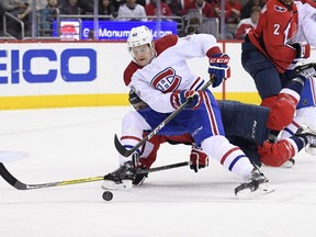 Montreal Canadiens center Byron Froese (42) skates with the puck as Washington Capitals center Jay Beagle falls to the ice during the second period of an NHL hockey game Friday, Jan. 19, 2018, in Washington.
