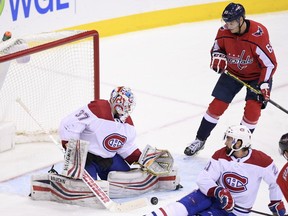 Canadiens goaltender Antti Niemi watches the puck in front of Capitals' Andre Burakovsky on Friday, Jan. 19, 2018, in Washington. At lower right is Canadiens defenceman David Schlemko.