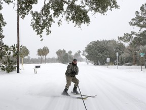 Richard Campsen skis behind a car on Waterway Blvd. while heavy snow comes down on the Isle of Palms, S.C., Jan. 3, 2018. "A gallon of gas is cheaper than a lift ticket," Campsen said.