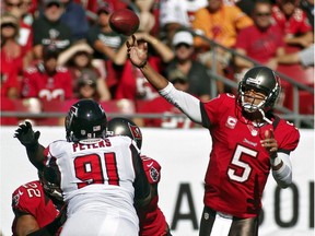 Tampa Bay Buccaneers quarterback Josh Freeman (5) throws a pass as he is pressured by Atlanta Falcons defensive tackle Corey Peters (91) during the first quarter of an NFL football game, Sunday, Nov. 25, 2012, in Tampa, Fla.