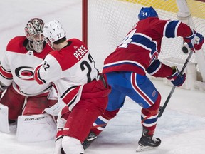 Canadiens' Charles Hudon scores the first of his two goals on the night past Hurricanes goalie Cam Ward while defenceman Brett Pesce looks on Thursday night at the Bell Centre.
