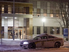 Police stand in the front doors of the courthouse in Maniwaki after two people were injured in a shooting there on Wednesday, Jan. 31, 2018.