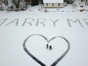 In this Jan. 7, 2018 photo provided by Ed Becker, Gavin Becker proposes to his long-time girlfriend Olivia Toft on Eight Crow Wing Lake near Nevis, Minn. Becker had his family's help etching out the big question with a snow blower in 25-foot-tall letters and a huge heart in the snow on the frozen lake. Then Gavin rented a plane and took Toft, who said yes, for a ride over the lake to see where his father took photos of the event.