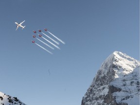 The airshow of the Patrouille Suisse, Northrop F-5E Tiger II fighter jets of the Swiss Air Force who perform with a Bombardier C Series passenger plane of Swiss Airlines, with the Eiger montain, right, to open the men's downhill race at the Alpine Skiing FIS Ski World Cup in Wengen, Switzerland, Saturday, Jan. 13, 2018. (Jean-Christophe Bott/Keystone via AP) ORG XMIT: XSAF103