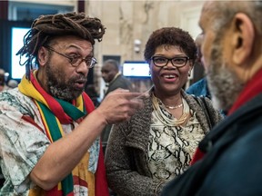 Michael P. Farkas, left, president of the Board of Directors of Black History Month, chats with Claudie Mompoint and Frantz Voltare Thursday night at Montreal city hall.