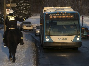 Montreal police officer on his horse waves to STM bus driver on Remembrance Rd. on Mount Royal on Tuesday, Feb. 6, 2018.