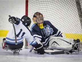 Mathieu Lelievre takes the puck to the net of Felix Rehel during a U18 girls and boys sledge hockey game at the Dollard-des-Ormeaux Civic Centre,  Sunday.