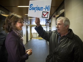 Retired teacher Chris Eustace holds up a sign during a discussion with Kathleen Weil, the minister responsible for the English-speaking community, at a one-day forum at Concordia University to reach out to anglophones and get their feedback, at Concordia University in Montreal, Friday, Feb. 16, 2018.