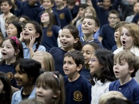 Roslyn School students react during a presentation Tuesday after learning their school has been given 30 new laptops.