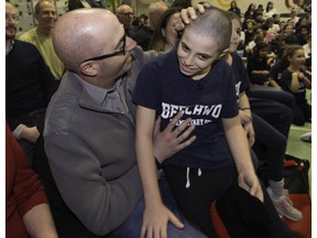 Lyle Goldsmith (left) rubs his 10-year-old son's head after Tyler shaved all his hair off during a school assembly at Beechwood Elementary in Pierrefonds to raise awareness and money for the Segal Cancer Centre last Friday. Tyler's father has been diagnosed with stage 4 colon cancer.