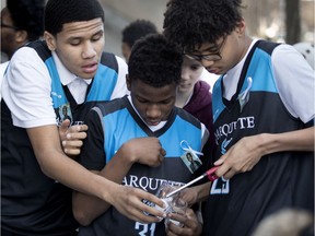 Wearing white ribbons and pictures of Blessing Moukoko, members of the basketball team light candles Thursday to remember the École Père-Marquette student who died a week after being found at the bottom of the pool.