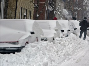 A Montrealer uses his shovel to find his snow-covered car in 2003.