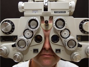Steven Carrier, President of the Quebec Association of Optometrists (not seen), performs an eye exam on Erik de Pokomandy at Optoplus in the east end of Montreal Friday July 29, 2011.