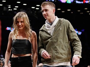 Genie Bouchard, walks the court with her blind date, John Goehrke, right, during the first half of an NBA basketball game between the Brooklyn Nets and the Milwaukee Bucks Wednesday, Feb. 15, 2017, in New York. They will be attending Super Bowl LII together.