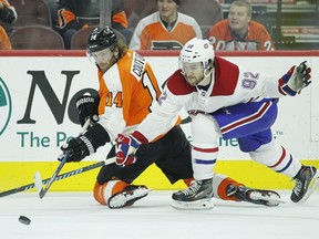 Philadelphia Flyers' Sean Couturier, left, passes the puck as Montreal Canadiens' Jonathan Drouin tries to intercept it during the overtime period of an NHL hockey game Tuesday, Feb. 20, 2018 in Philadelphia. The Flyers won 3-2.