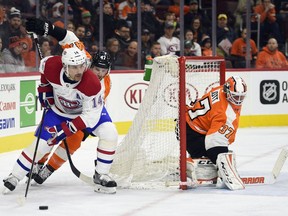 Philadelphia Flyers goalie Brian Elliott (37) looks for the puck as Montreal Canadiens' Tomas Plekanec (14) skates around the net in front of Andrew MacDonald during the third period of an NHL hockey game, Thursday, Feb. 8, 2018, in Philadelphia. The Flyers won 5-3.
