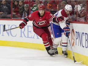Canadiens defenceman Victor Mete, right, reaches for the puck ahead of Hurricanes' Jaccob Slavin Thursday night in Raleigh, N.C.