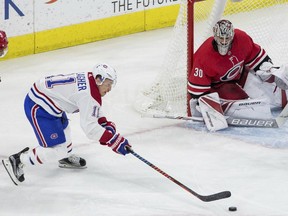 Montreal Canadiens' Brendan Gallagher (11) reaches for a puck ahead of Carolina Hurricanes' Noah Hanifin (5) and goalie Cam Ward (30) during the third period of an NHL hockey game in Raleigh, N.C., Thursday, Feb. 1, 2018. Carolina won 2-0.