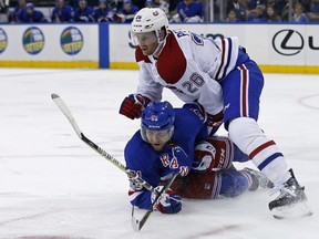 Rangers' David Desharnais (51) falls to the ice fighting for the puck with Canadiens' Jeff Petry (26) during game in New York last October.