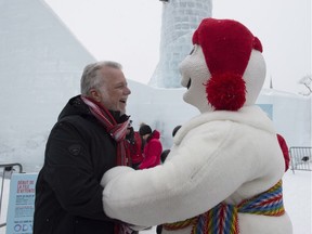 Quebec Premier Philippe Couillard, left, meets Bonhomme, during a visit at Quebec's winter carnival in Quebec City on Saturday, February 10, 2018.