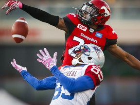 Montreal Alouettes' Duron Carter, bottom, has the ball knocked away by Calgary Stampeders' Tommie Campbell during first half CFL football action in Calgary, Saturday, Oct. 15, 2016.