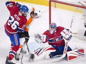 Canadiens goaltender Charlie Lindgren makes the save on Flyers centre Nolan Patrick as Jeff Petry battles Monday night at the Bell Centre.