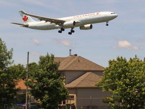 An airplane flies over houses on Marler Ave. in Dorval on its final approach to Trudeau airport.