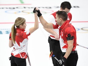 Canada's Kaitlyn Lawes and John Morris slap hands against Switzerland in the mixed doubles curling gold-medal game at the Pyeongchang Olympics on Feb. 13.
