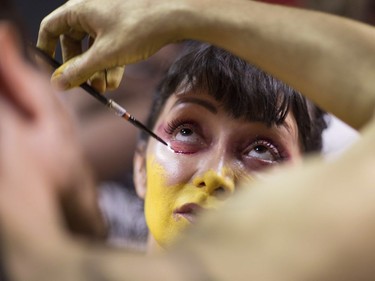 A nude model getting prepares for the Polar Bear Paint body-painting event in the rain and cold of New York City's Times Square.