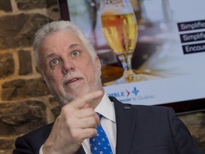 Quebec Premier Philippe Couillard talks to the media in a Quebec City pub on Wednesday, Feb. 21, 2018.