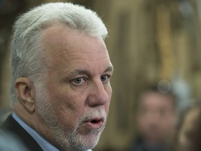 Quebec Premier Philippe Couillard responds to reporters questions during a visit of a furniture store warehouse in Quebec City, Wednesday, February 28, 2018.