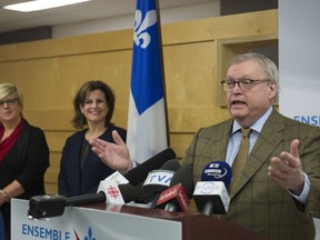 Quebec Health Minister Gaetan Barrette announces an agreement with nurse practitioners, Wednesday, February 14, 2018 in Quebec City. Quebec Justice Minister Stephanie Vallee, centre, and Lucie Tremblay, president of the nurse practitioners union, look on.