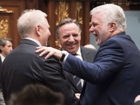Who's smiling now? New poll leader Francois Legault of the CAQ is flanked on the left by Parti Quebecois Leader Jean-Francois Lisee and Quebec Premier Philippe Couillard, right.