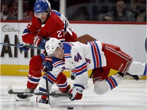 New York Rangers defenceman Neal Pionk falls to the ice as he tries to take the puck from Montreal Canadiens left-winger Alex Galchenyuk on Feb. 22, 2018.