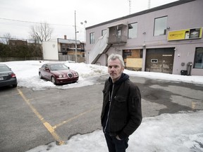 Guénaël Charrier stands in a parking lot next to his backyard on Friday, Feb. 23, 2018. A proposed development on Lajeunesse St. in Villeray would see condo buildings that are the equivalent of four storeys high replace the parking lot and the two-storey building behind him (former headquarters of Diamond Taxi).