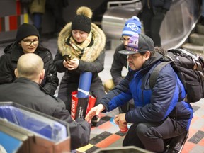 The Wolf Pack, a volunteer patrol group (from left)  Annie Roussy-Ste-Croix, Shalyna Kolitsidas, Matthew Coutu-Moya, and Samuel Medrano) visit and bring supplies to a homeless man named Corey in downtown Montreal, March 8, 2018. (Christinne Muschi / MONTREAL GAZETTE)