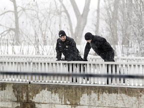 Montreal Police officers look down from a foot bridge over the Riviere des Prairies during search for Ariel Jeffrey Kouakou on Tuesday March 13, 2018.