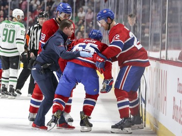 Montreal Canadiens Andrew Shaw is helped to his feet by teammates Karl Alzner, right, Noah Juulsen and athletic therapist Graham Rynbend after check by Dallas Stars Greg Pateryn during third period of National Hockey League game in Montreal Tuesday March 13, 2018.