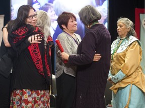 After her testimony at the National Inquiry into Missing and Murdered Indigeous Women and Girls in Montreal on March 15, 2018, Nathalie Hervieux (centre) is presented with a red-wrapped eagle feather.   (Christinne Muschi / MONTREAL GAZETTE)