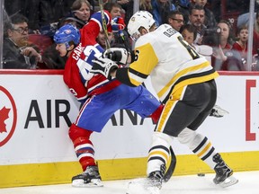 Montreal Canadiens Daniel Carr is taken into the boards by Pittsburgh Penguins Jamie Oleksiak during first period of National Hockey League game in Montreal, Thursday March 15, 2018.