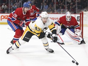 Canadiens Mike Reilly, left, Karl Alzner and goalie Antti Niemi watch as Penguins' Conor Sheary tries to control the puck Thursday night at the Bell Centre.