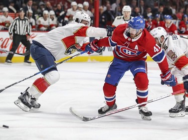 Florida Panthers Keith Yandle, left, and Aaron Akblad flank Montreal Canadiens Paul Byron during first period of National Hockey League game in Montreal Monday March 19, 2018.