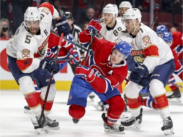 Montreal Canadiens Brendan Gallagher breaks out of a scrum with Florida Panthers Aaron Ekblad, left, and Colton Sceviour during third period of National Hockey League game in Montreal Monday March 19, 2018.