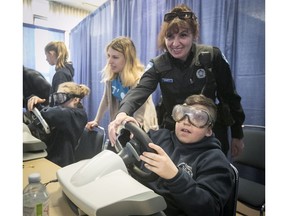 Montreal Police Constable Liliana Bellucci helps Grade 6 student Massimo Fortino manipulate a simulated drunk-driving scenario at the Sarto-Desnoyers Community Centre in Dorval.