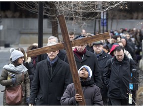 Sister Vianne carries a cross during the annual Way of the Cross march in Montreal March 30, 2018.