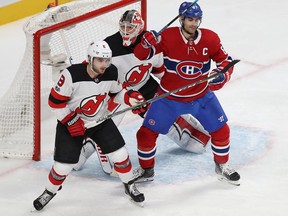 Canadiens left wing Max Pacioretty in from of net of New Jersey Devils goalie Cory Schneider with Devils' Will Butcher  in Montreal on December 14, 2017.