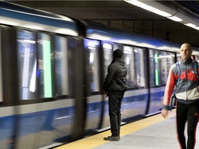 A person waits as a train arrives at the Montmorency métro station.