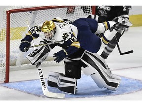 Notre Dame's Colin Theisen (13) collides with Providence goaltender and Canadiens prospect Hayden Hawkey during the first period of an NCAA college hockey regional tournament game on Saturday, March 24, 2018, in Bridgeport, Conn.